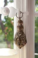 Vintage ornament hanging from window latch