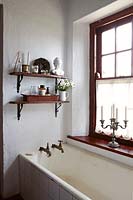 Wooden shelves above bath