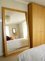 Wooden mirror propped against wall