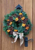Christmas wreath of conifer foliage, pine cones and orange slices