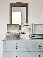 Eclectic art and accessories on vintage chest of drawers