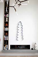 Minimal fireplace with wall mounted sculpture above