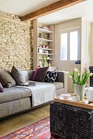 Beige sofa against exposed stone wall