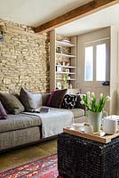 Beige sofa against exposed stone wall