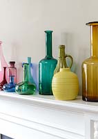 Colourful glassware on mantlepiece
