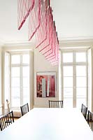 Pink suspended light by Johanna Grawunder over dining table