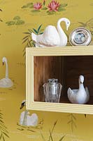 Vintage swan ornaments on box shelf