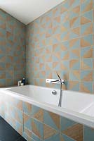 Bath surrounded by patterned tiles