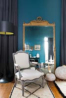 Classic armchair in front of vintage mirror
