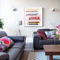 Patterned cushions on black leather sofas