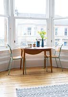 Compact dining area by bay window