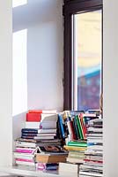 Books stacked on windowsill