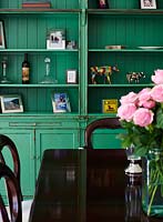 Green bookshelves in dining room