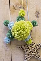 A star made of wool pompoms hanging from a door handle