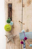 Wool pompoms in different sizes hanging from a door handle