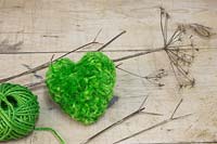 A green heart pompom made from wool