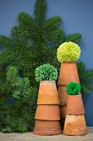 Wool pompoms on top of terracotta pots