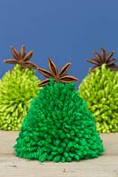 Miniature Christmas trees made from wool pompoms and star anise pods