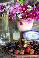 Fresh fruits and flowers on garden table