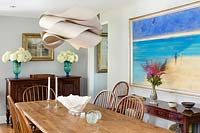 Modern pendant light above traditional dining table