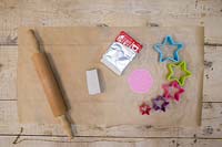 Making clay stars - Materials required are white modelling clay, silicone flower mould, star shape cutters, string, scissors, rolling pin and a skewer