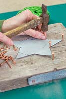 Making a christmas star decoration - Hammer the copper nails at each corner point of the star