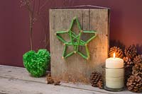 Making a christmas star decoration - A decorative plinth with a green woollen star wrapped around copper nails 