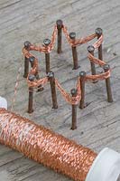 Making copper wire star decorations - Repeat the weaving of the copper wire for roughly 10-12 times, this helps to strengthen the star as well as making the shape more distinctive