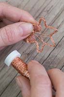 Making copper wire star decorations - Wrap additional copper wire across the inner corners of the star to create a second star 