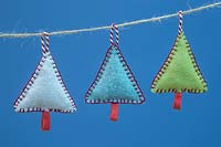 Making stitched felt christmas decorations - miniature christmas trees made from felt and decorative string