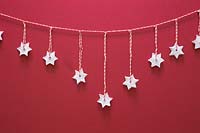 Miniature clay stars hanging from red and white striped string