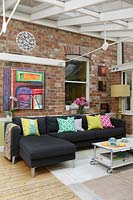 Black corner sofa with colourful cushions