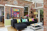 Black corner sofa with colourful cushions
