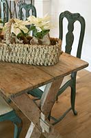 Basket of Poinsettia plants on wooden table