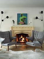 Armchairs by fireplace