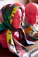 Patterned scarves displayed on pink mannequins