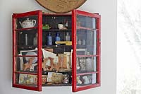Ornaments and collectibles in red cabinet