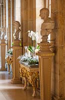 Christmas decorations with white orchids, candles and wreaths  in the antique passage, Castle Howard