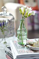 Freesia flowers in glass bottle