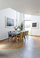 Open plan dining area with oak and concrete flooring