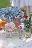 Floral display of Peony, Hydrangea and Tulip flowers on garden table
