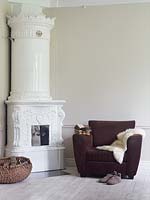 Modern armchair beside ornate fireplace