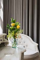 Vase of Roses and Alchemilla flowers on dressing table
