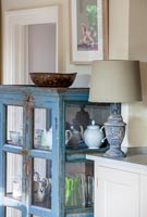 Distressed blue cabinet with vintage accessories