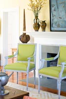 Green armchairs by fireplace