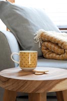 Patterned mug on wooden side table