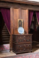 A George II chest of drawers with antique accessories and oak panelling