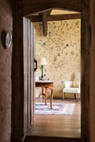 View from hallway into room with handpainted floral design on the walls by Arabella Arkwright - Cothay Manor