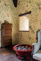 Handpainted floral wall design by Arabella Arkwright. With an 18 century Dutch inlaid cabinet and bowl of 400 polished stone eggs - Cothay Manor