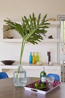 Vase of tropical foliage on dining table